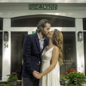 a man and woman kissing in front of a building