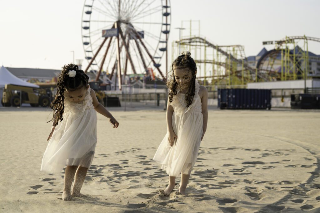 two girls in white dresses walking on the beach