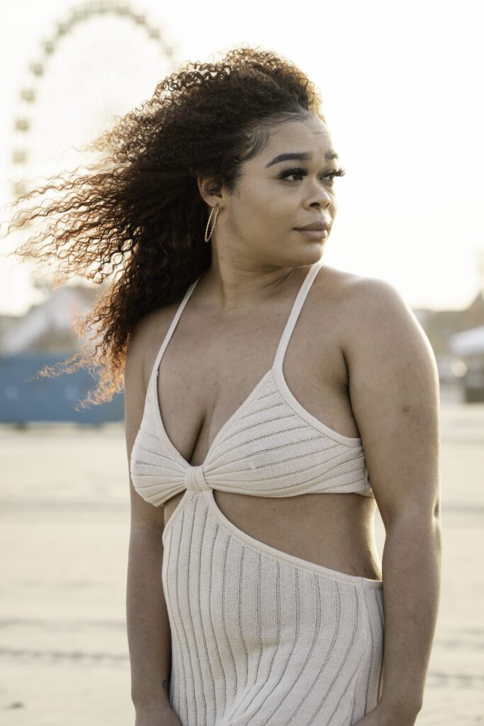 a woman with very large breast standing in front of a ferris wheel