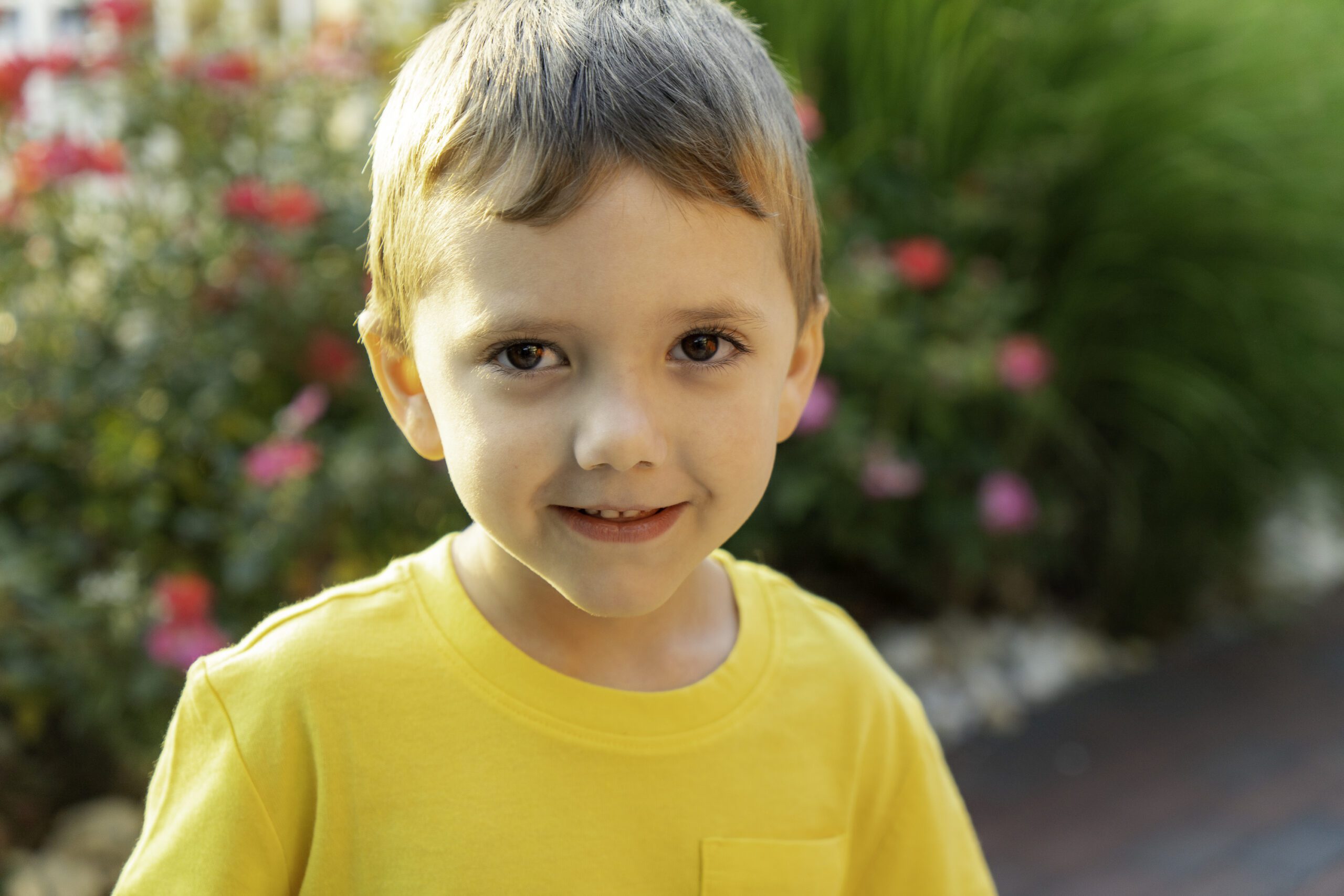a young boy with grey hair and yellow shirt