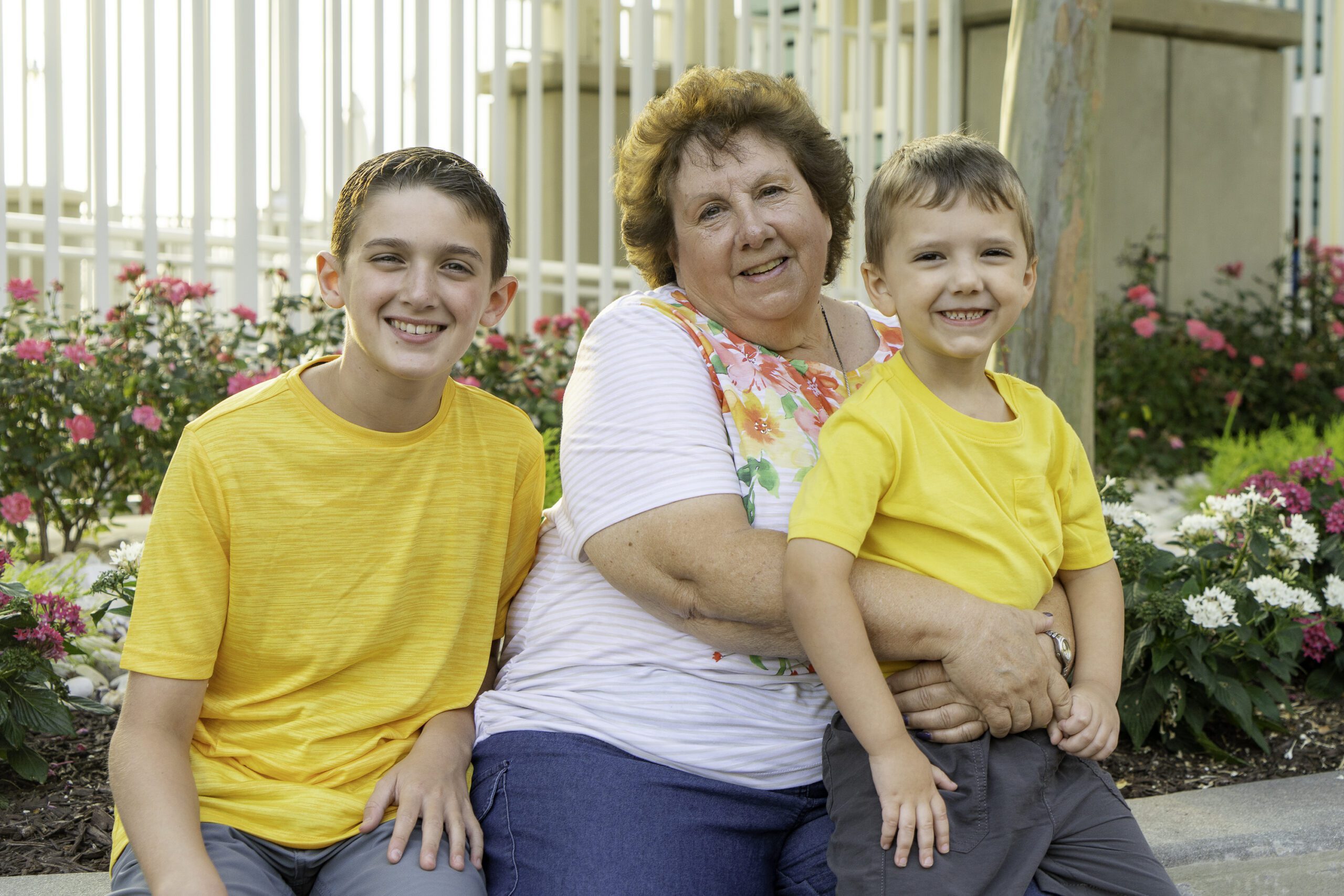 an older woman and two young boys sitting on a bench