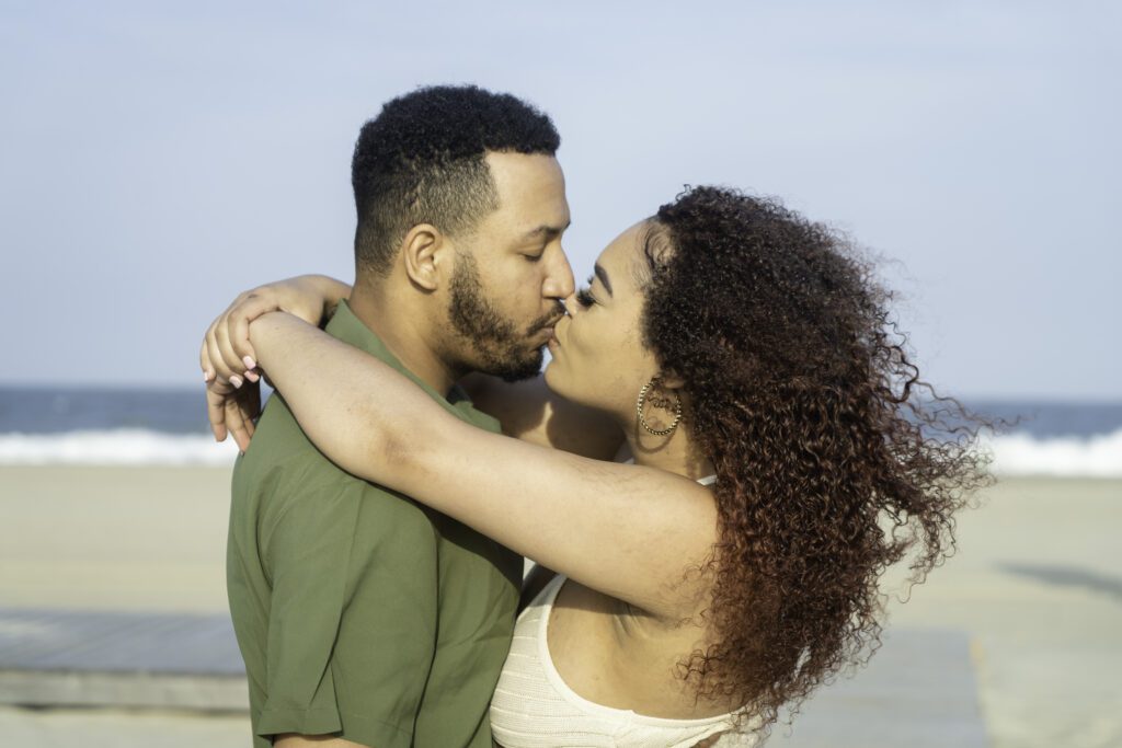 a man and woman are kissing on the beach