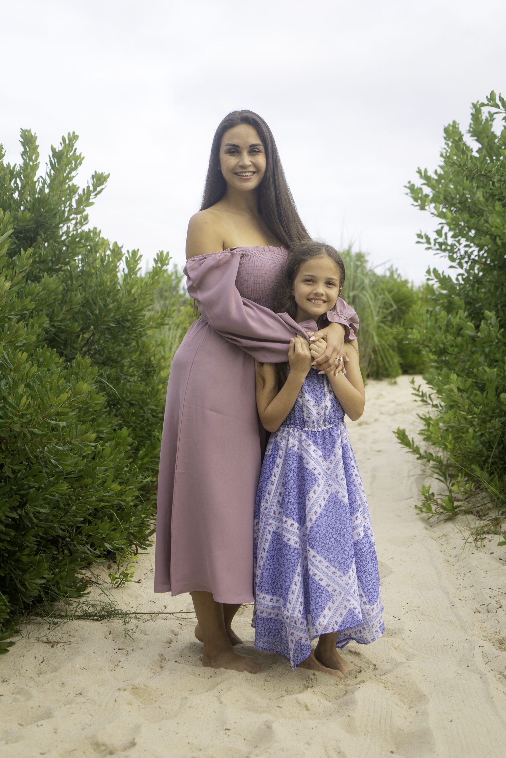 a woman in a purple dress holding a little girl