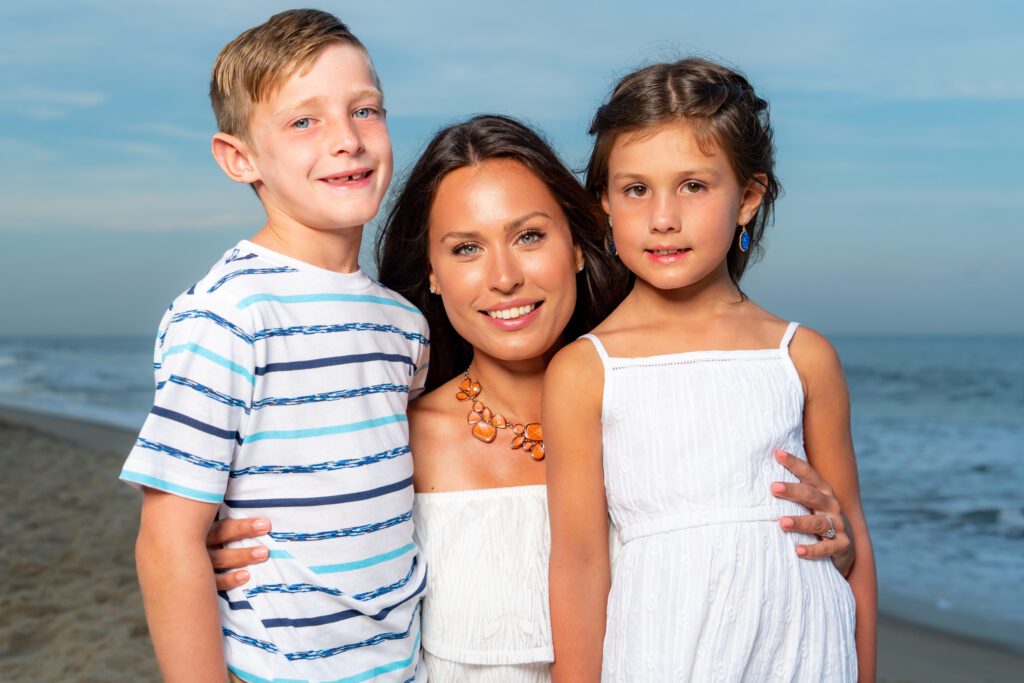 three children posing for a photo on the beach