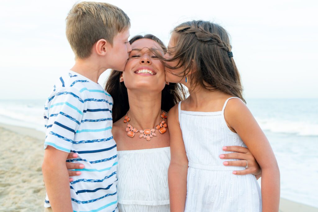 three children kissing each other on the beach