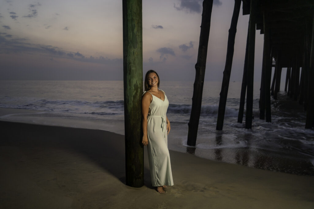 a woman in a white dress standing on the beach