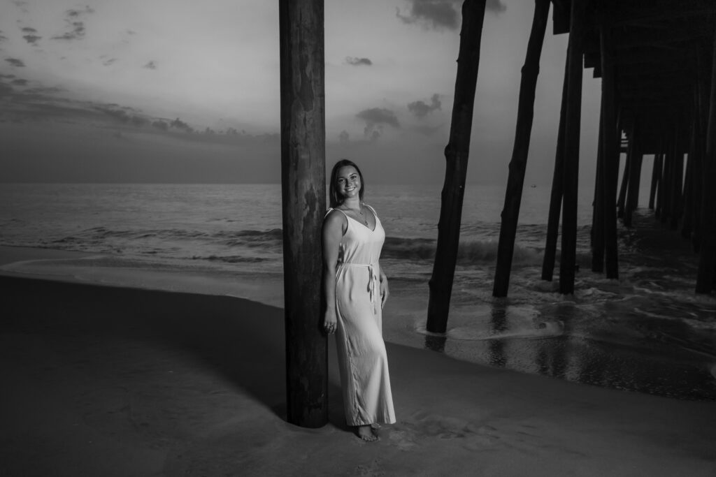a woman in a white dress standing under a pier