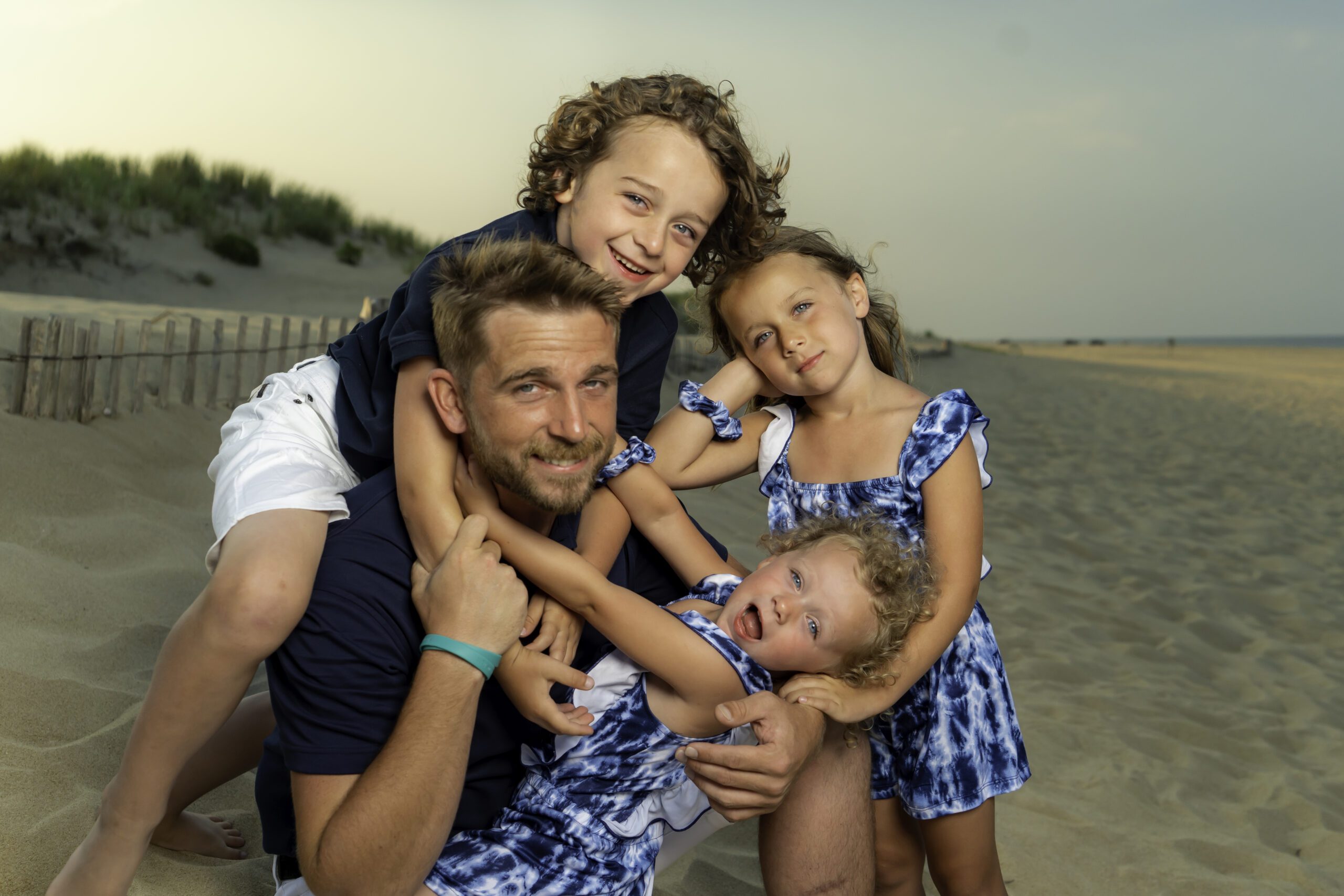 a man and two children are posing for a picture on the beach