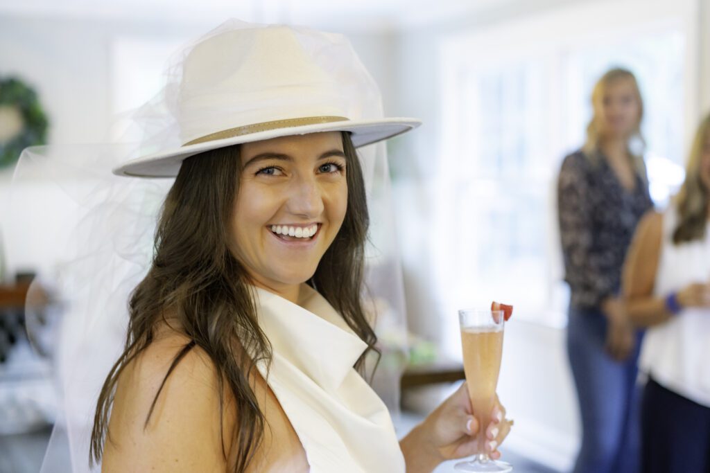 a woman wearing a white hat holding a drink