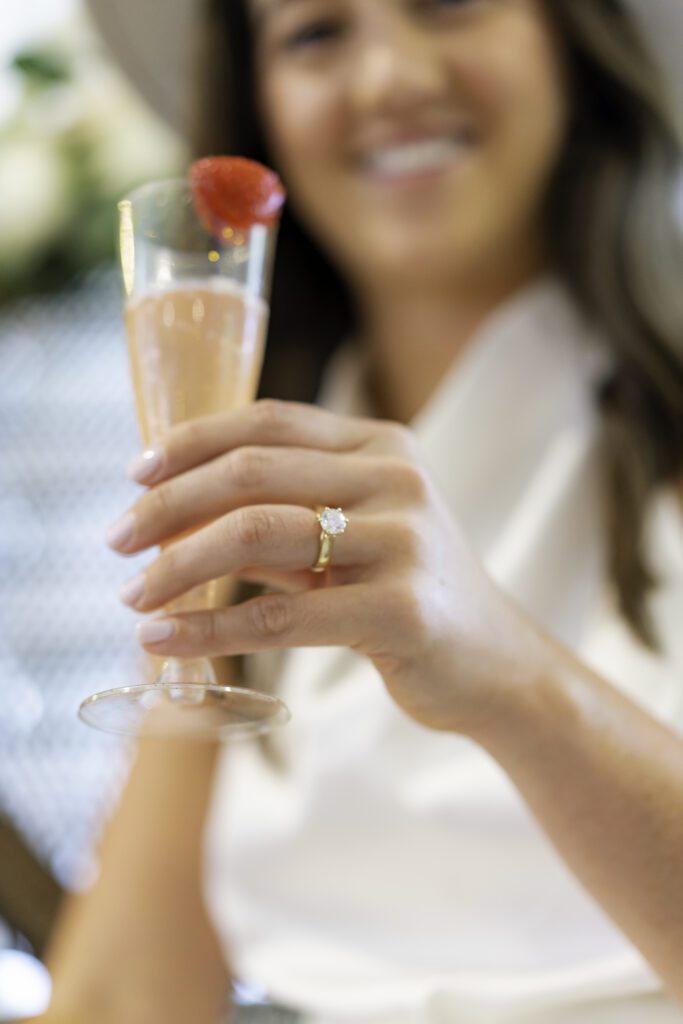 a woman holding a wine glass with a strawberry on it