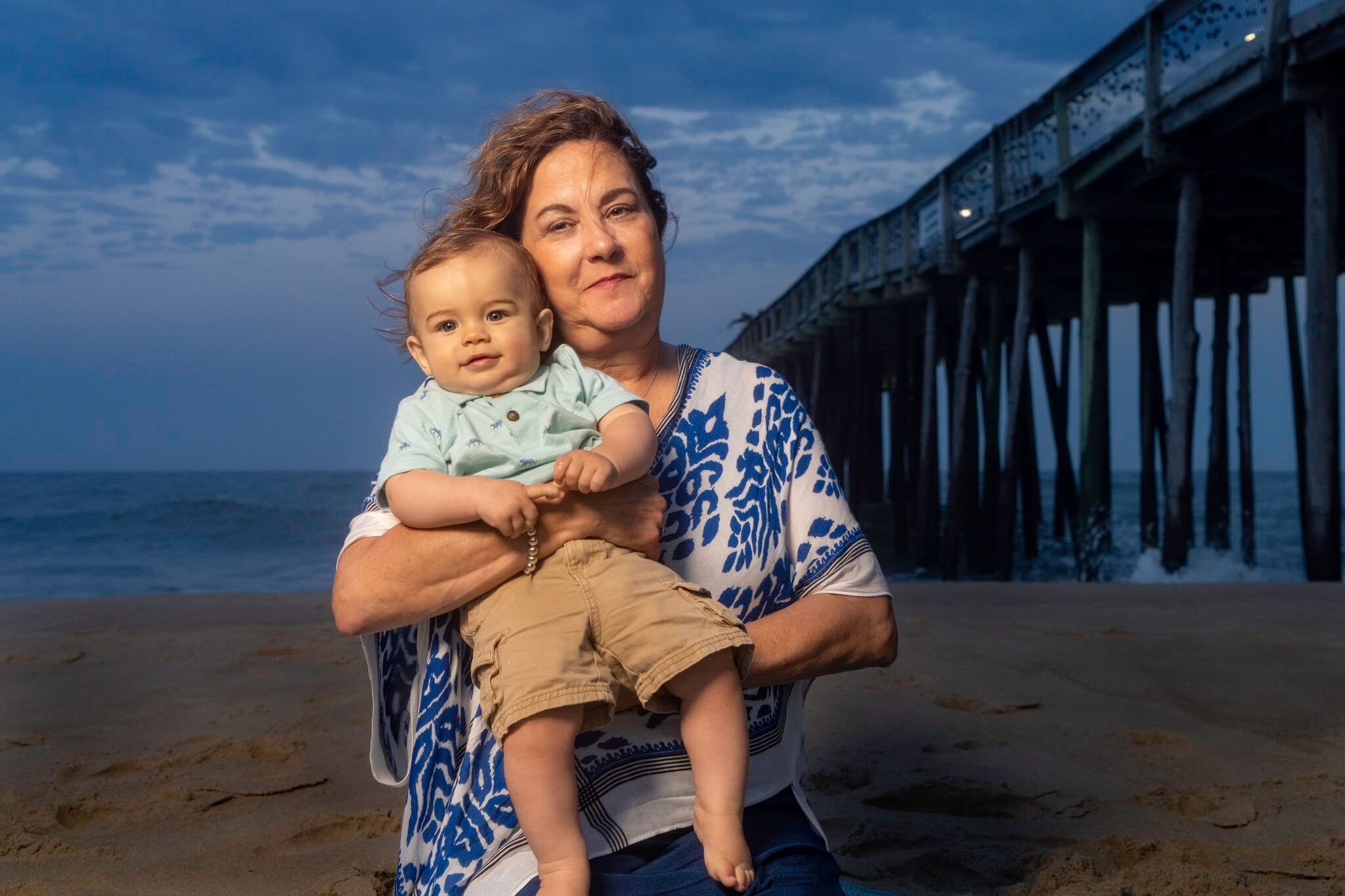 a woman on the beach holding a baby in her arms