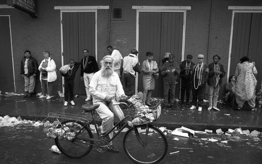 a man riding a bike down a street next to a bunch of people