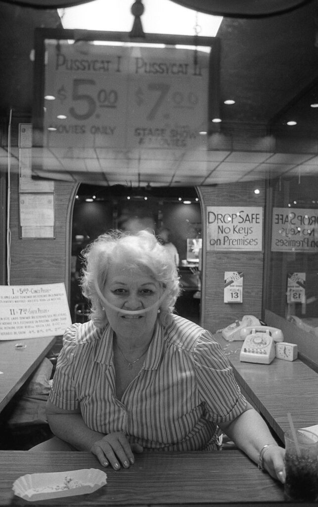 a woman sitting at a table with a sandwich in front of her