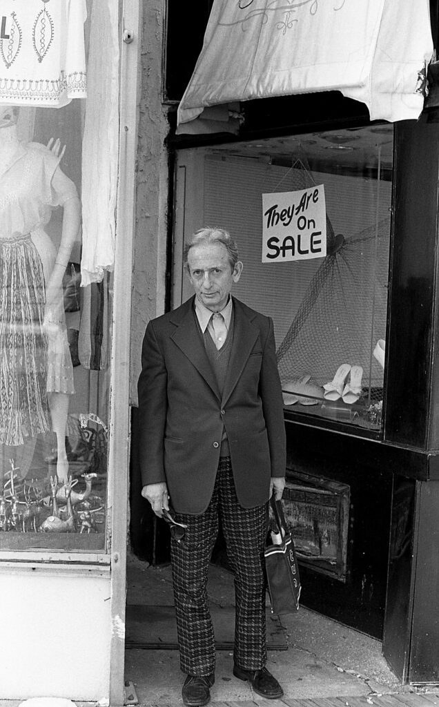 a man in a suit standing outside of a store