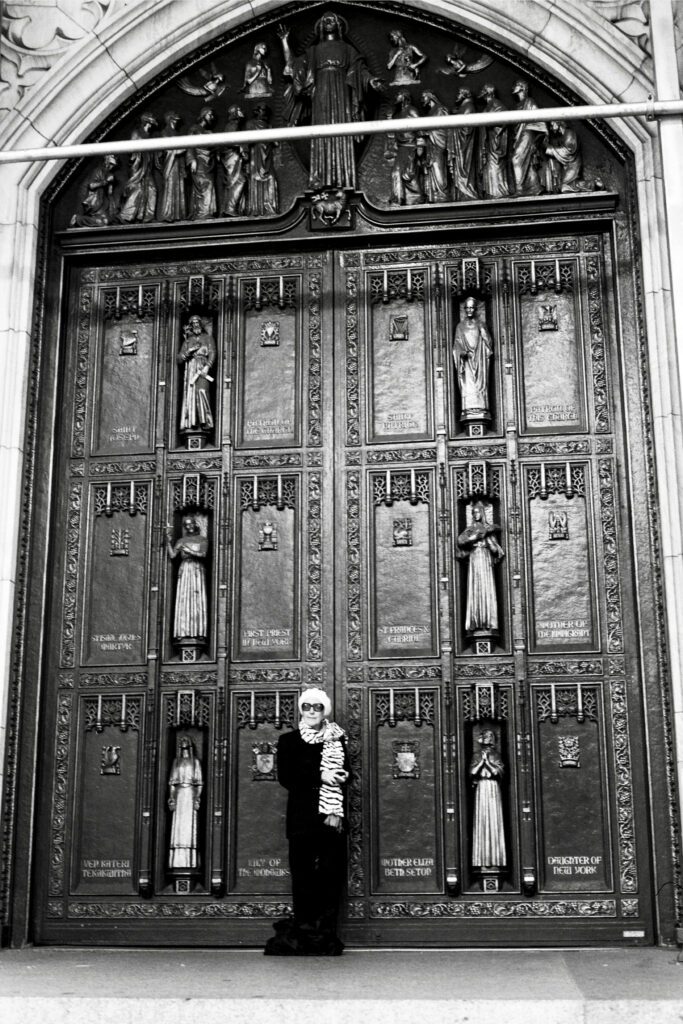 a woman standing in front of a large wooden door