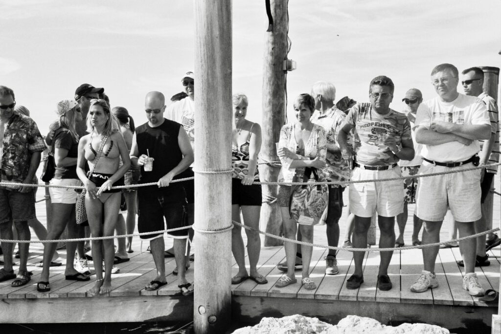 a group of people standing on top of a pier