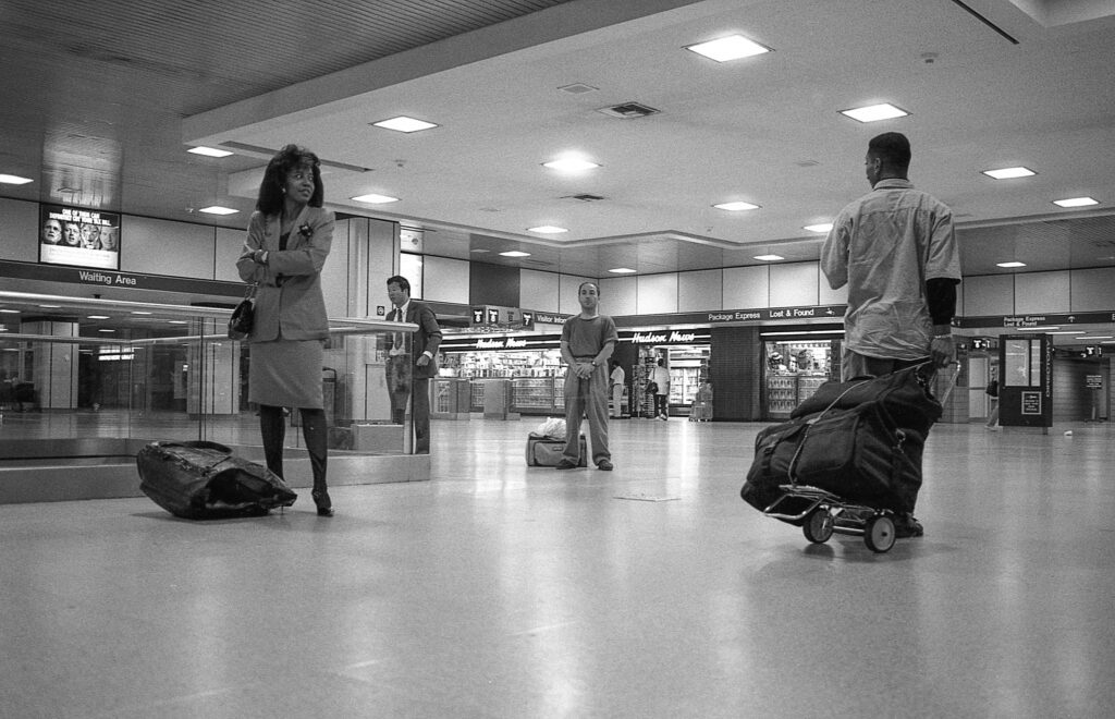 a group of people with luggage walking through an airport