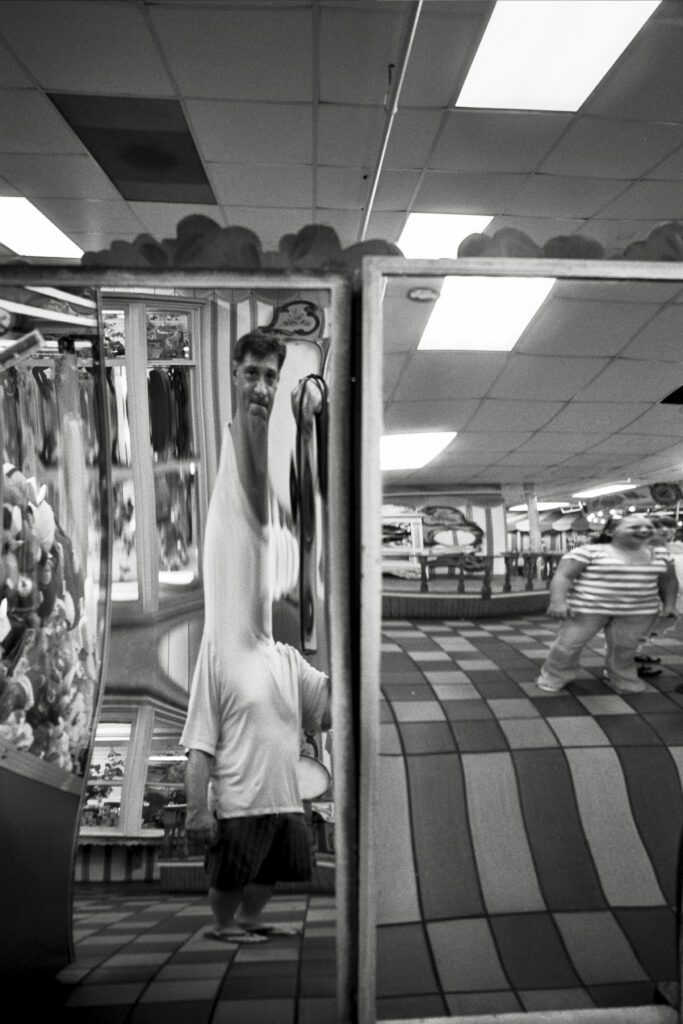 a man standing in front of a mirror holding a tie