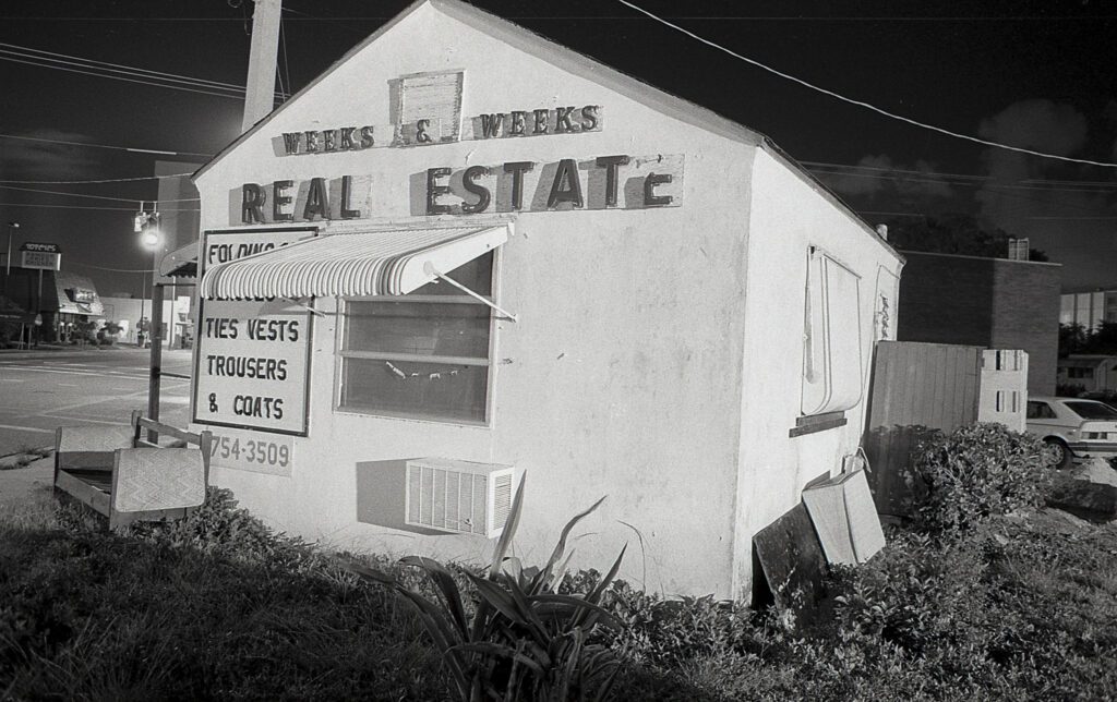 a black and white photo of a real estate store