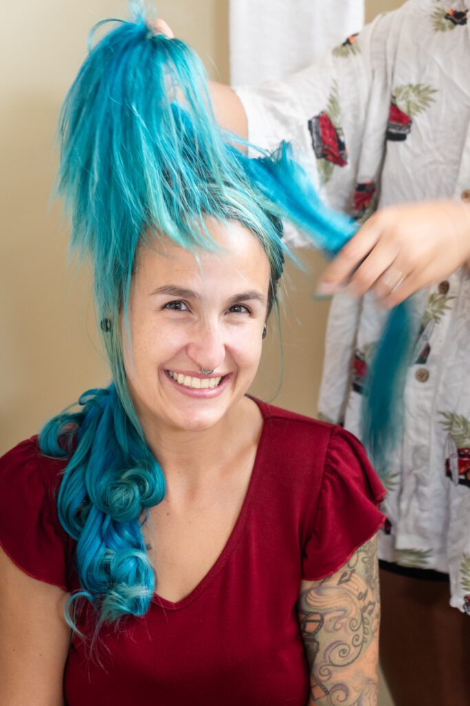 a woman with blue hair is getting her hair dyed