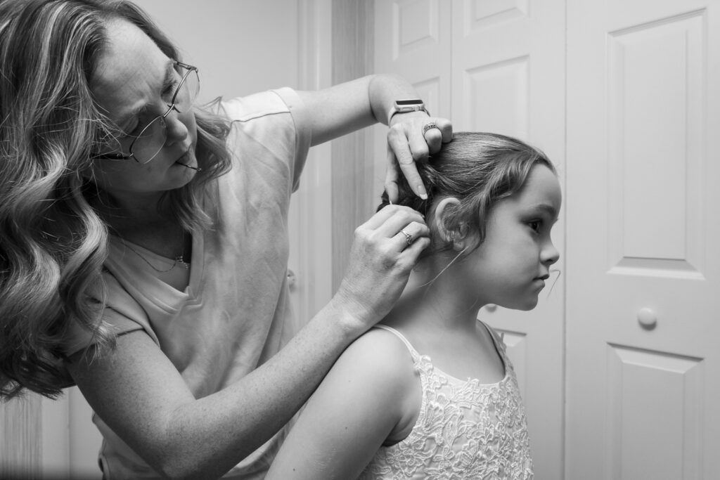 a woman helping a little girl get her hair done