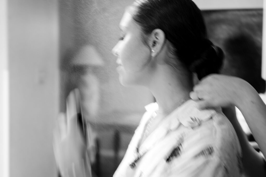 a woman is blow drying her hair in the mirror