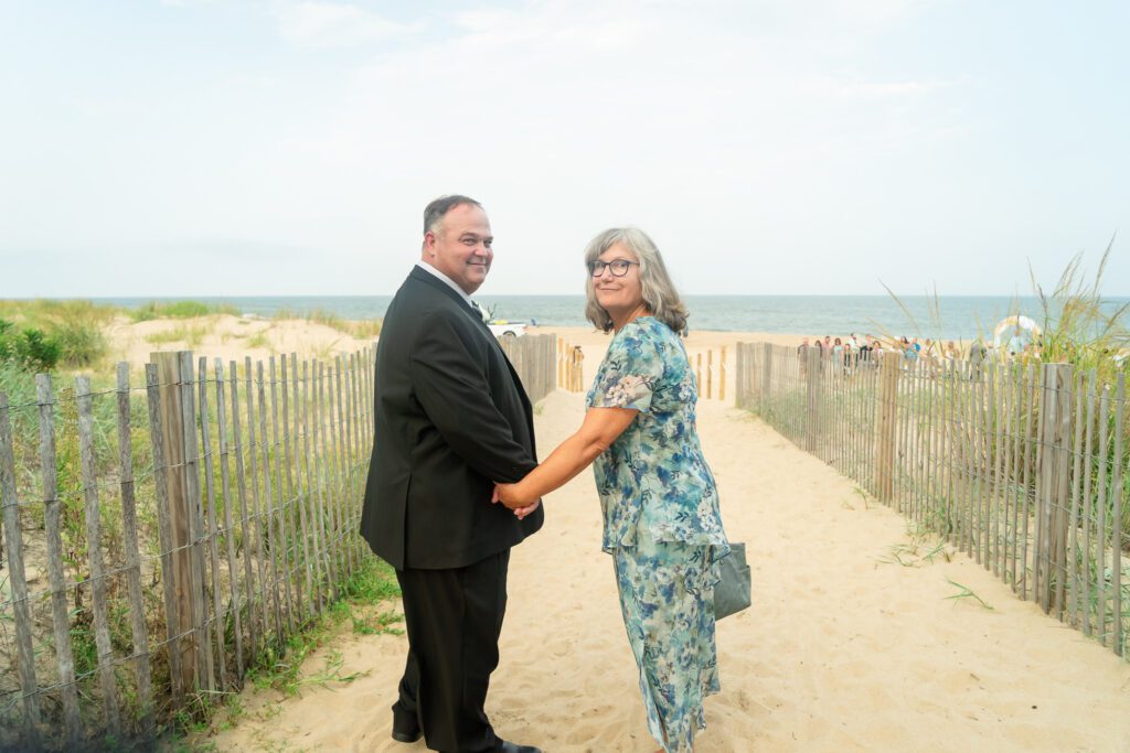 a man and woman shaking hands on the beach