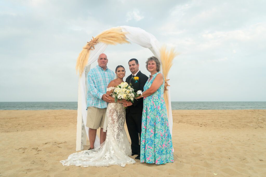 a man and two women pose for a photo on the beach