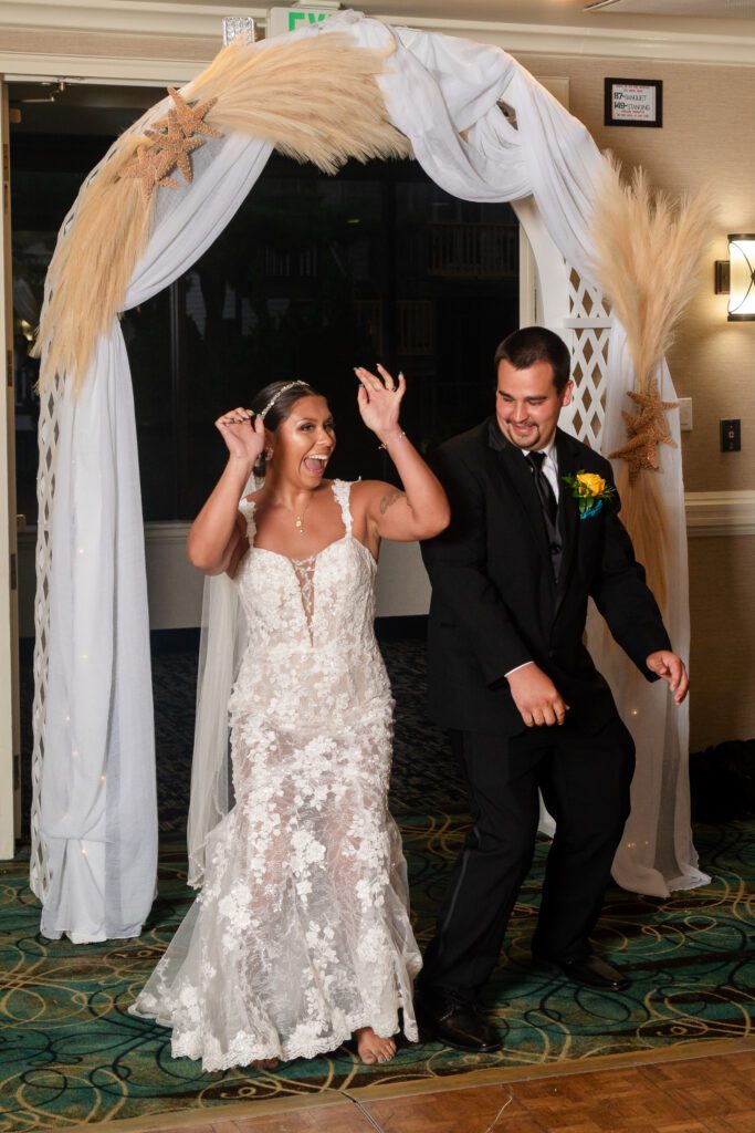 a bride and groom are dancing under a wedding arch