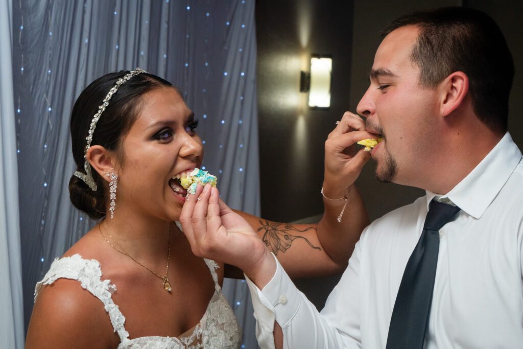 a bride and groom feeding each other cake