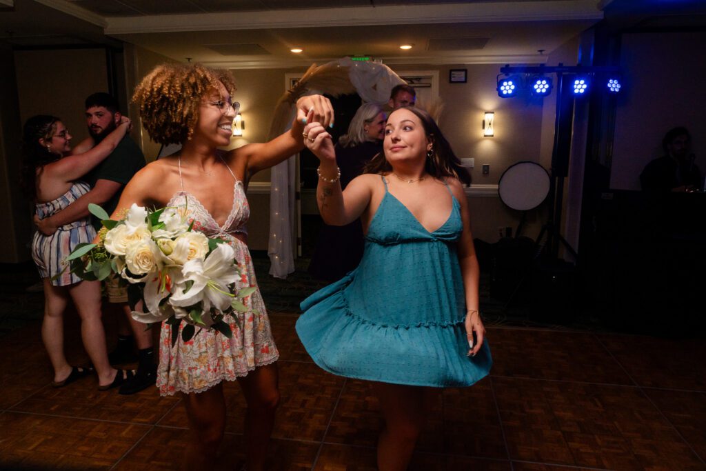 two women in dresses are dancing on the dance floor