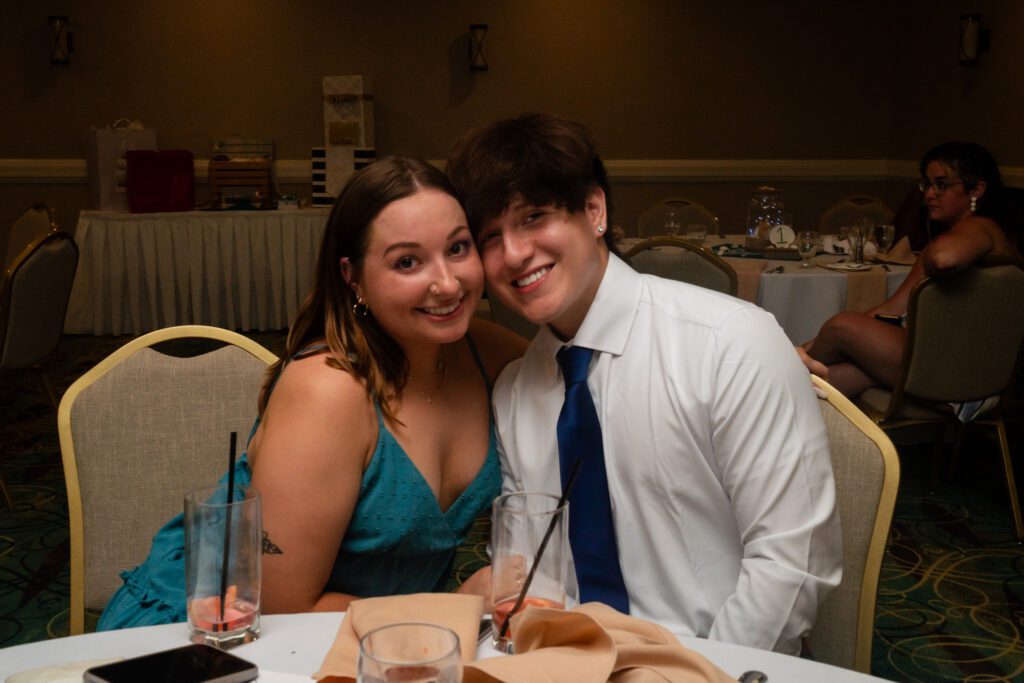 a man and woman sitting at a table with drinks