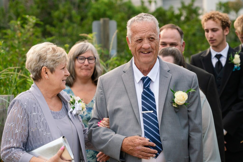 an older man in a suit and tie standing next to a woman