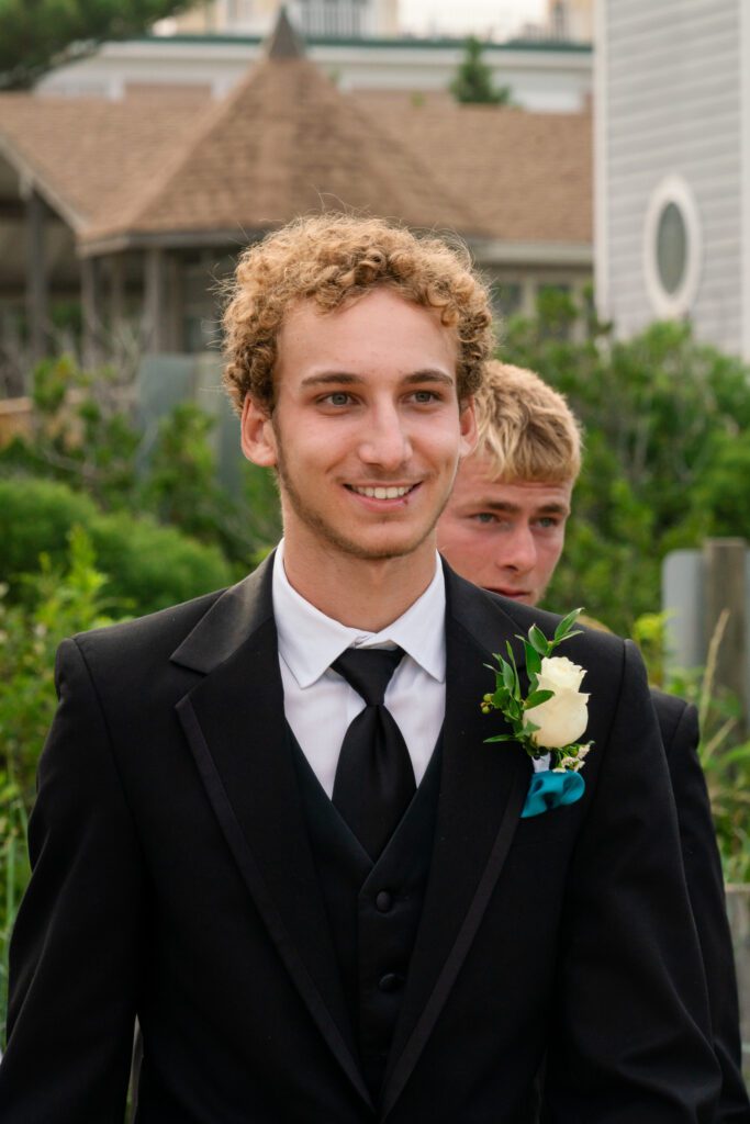 a man in a tuxedo smiles at the camera