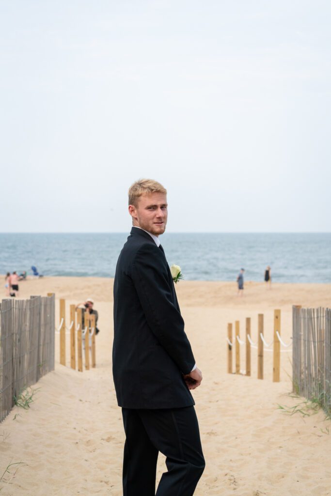 a man in a suit standing on the beach