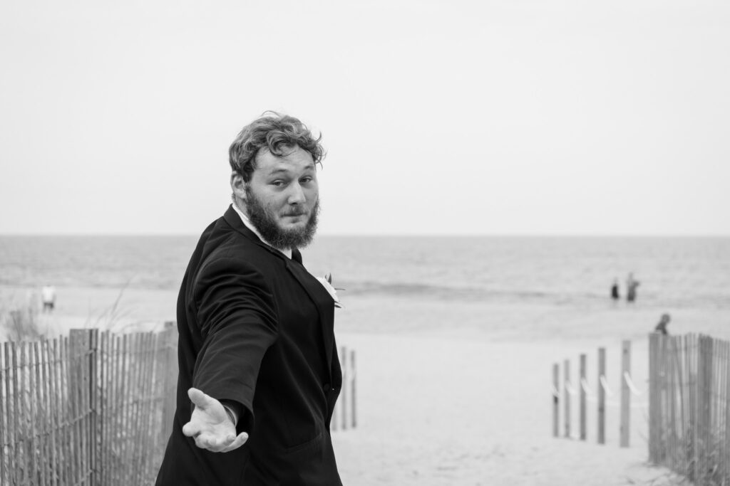 a man in a suit pointing at the beach