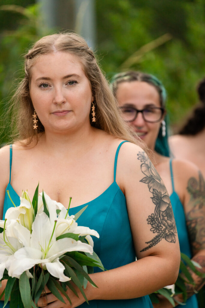 a woman in a blue dress holding a white flower