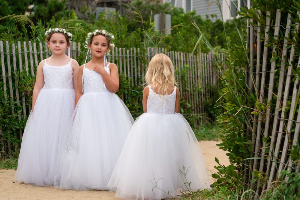 three little girls dressed in white dresses standing next to each other