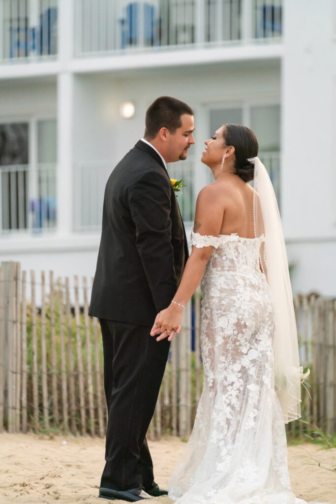 a bride and groom standing on the beach