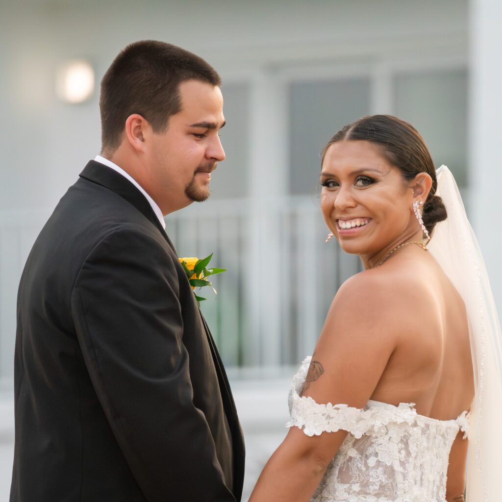 a bride and groom smile at each other