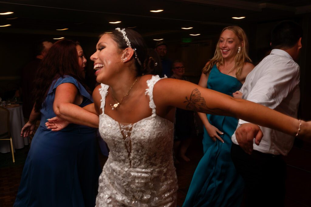 a woman in a white dress dancing with other people