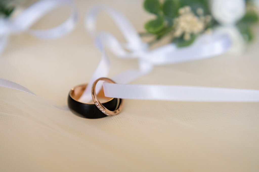 two wedding rings tied to a white ribbon