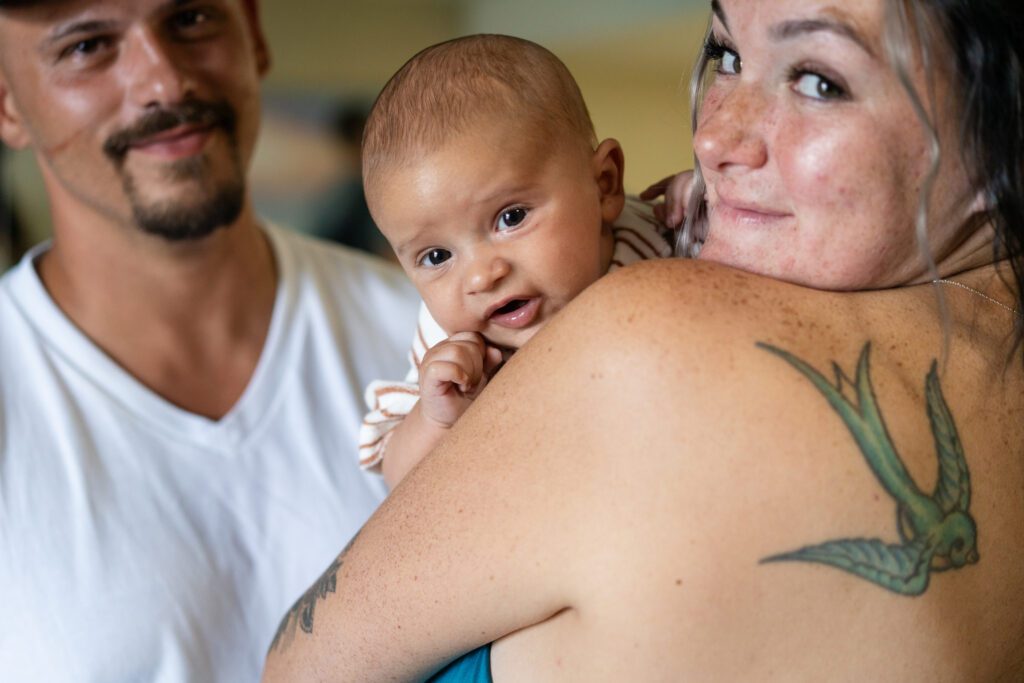 a man and woman holding a baby in their arms