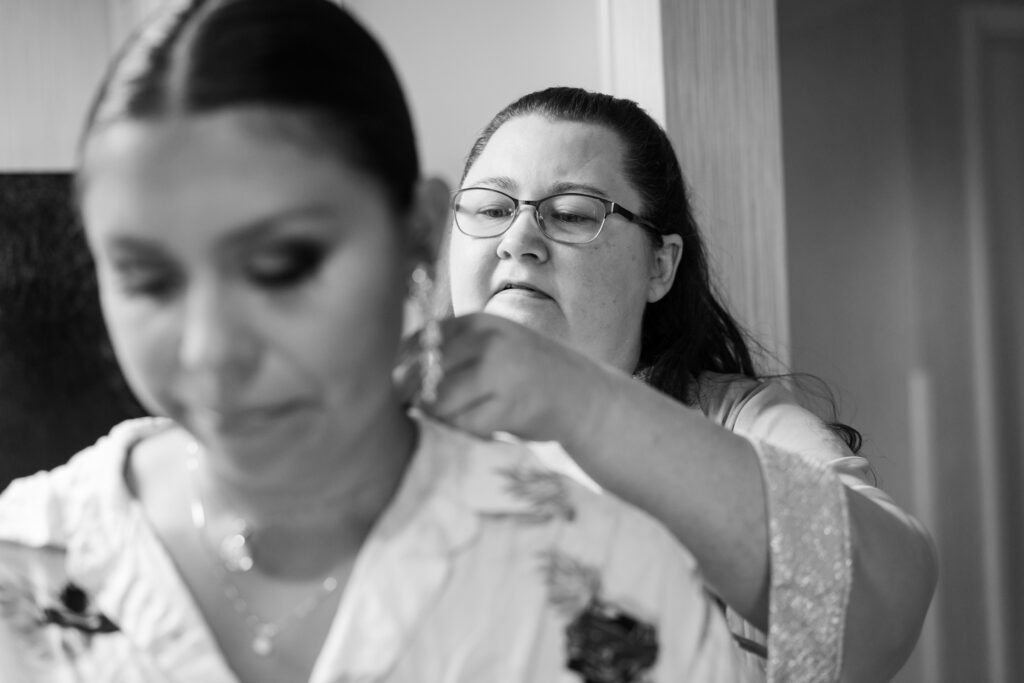 a woman is helping another woman fix her hair