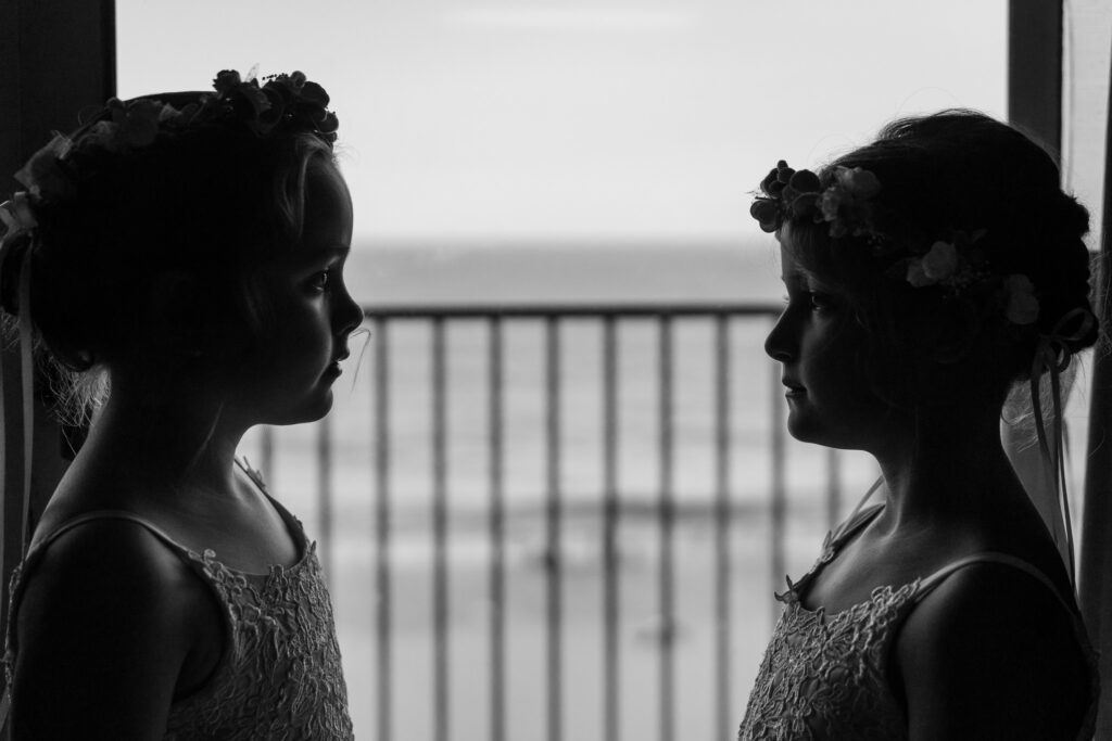 two women standing next to each other in front of a window