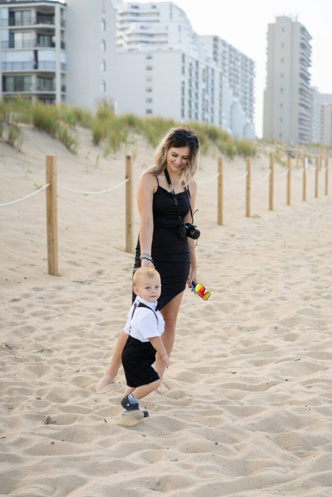 a woman and child on the beach playing with a ball