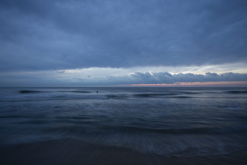 the sky is dark and cloudy over the ocean