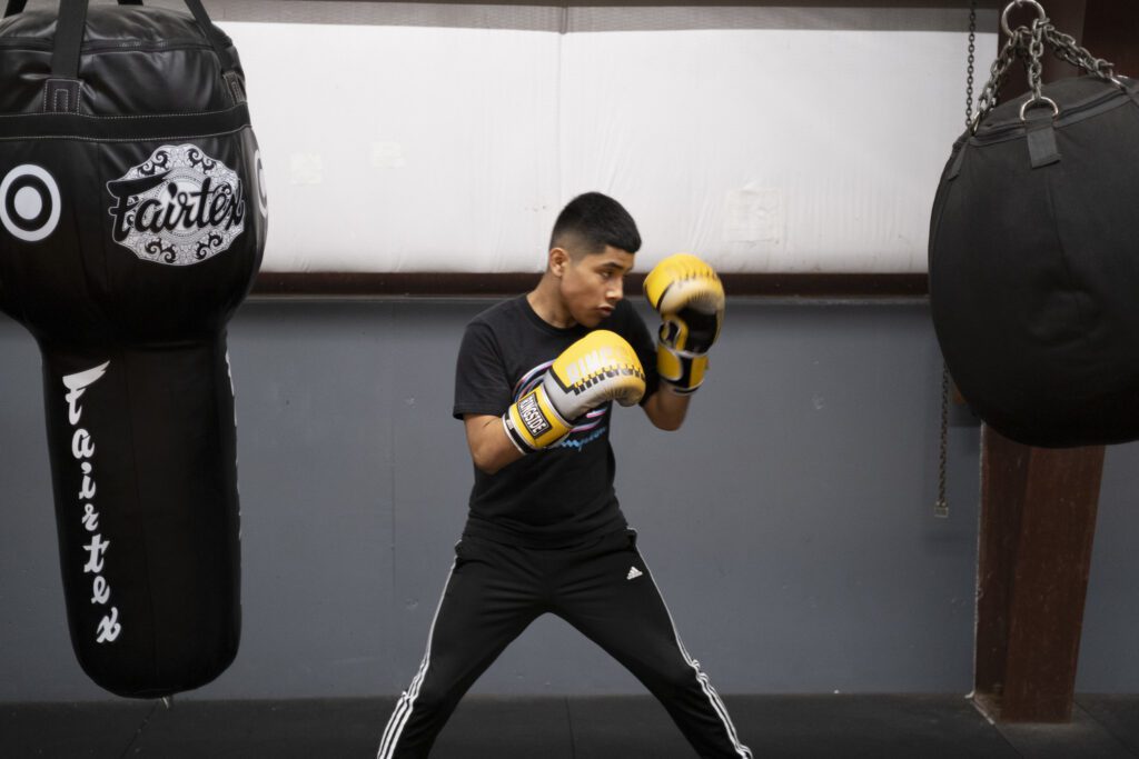 a man in black shirt and yellow boxing gloves