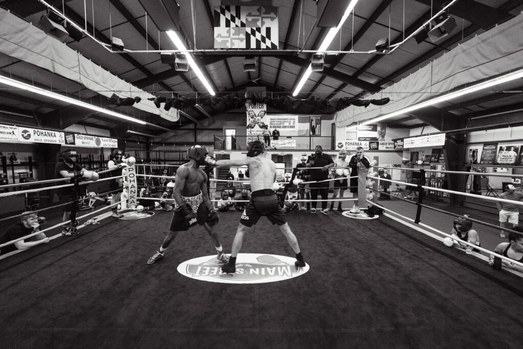 two men standing in a boxing ring during a training session