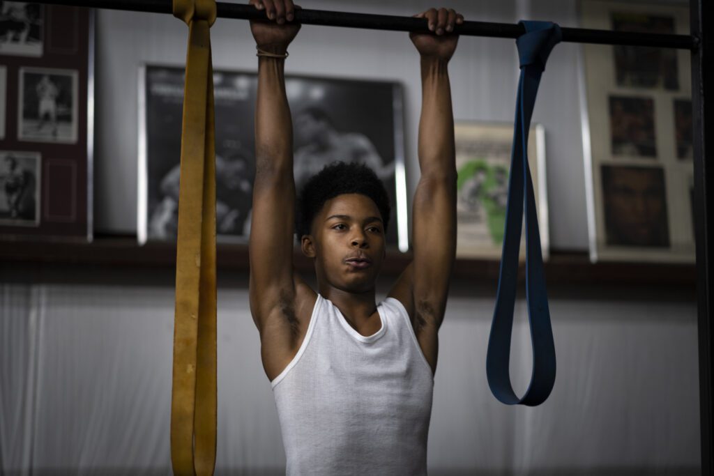 a young man is doing pull ups on a bar